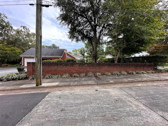 view of side of property with a fenced front yard and brick siding