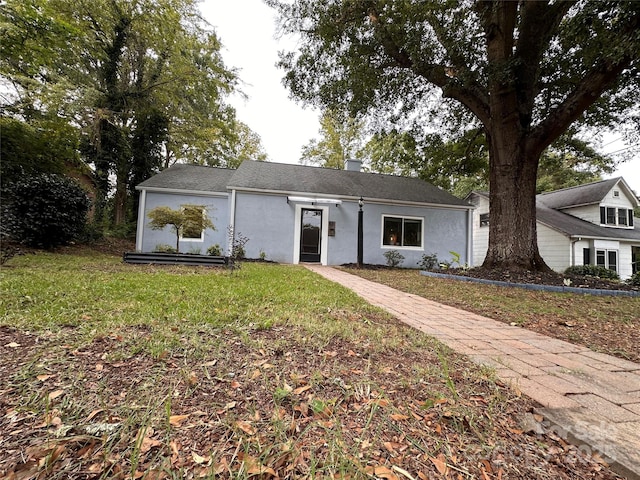 view of front facade featuring stucco siding and a front yard