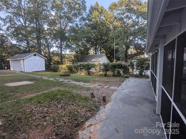 view of yard with an outbuilding, a shed, and a patio