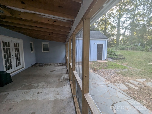 view of patio / terrace with an outbuilding, french doors, and a carport