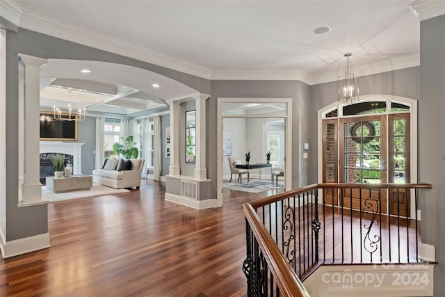 entryway with a notable chandelier, coffered ceiling, crown molding, and dark hardwood / wood-style flooring