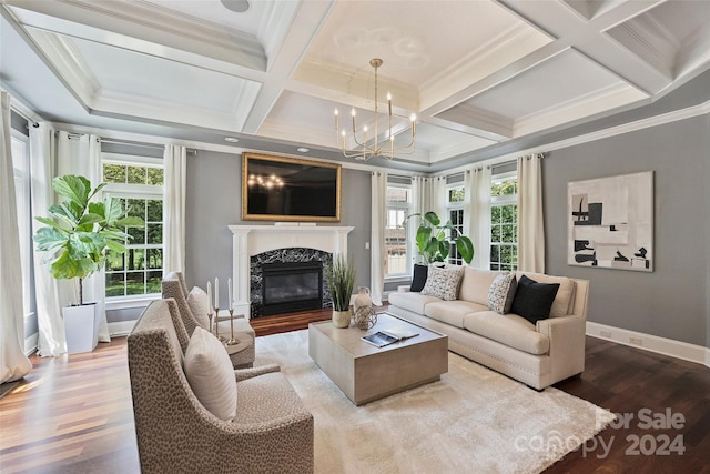 living room featuring coffered ceiling, ornamental molding, a fireplace, and light hardwood / wood-style floors