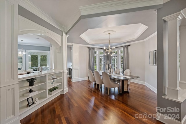 dining room with crown molding, a tray ceiling, an inviting chandelier, and dark wood-type flooring