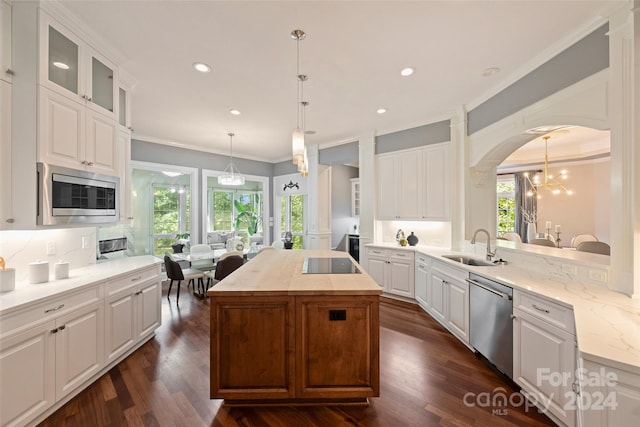 kitchen with white cabinets, appliances with stainless steel finishes, a kitchen island, and dark hardwood / wood-style flooring