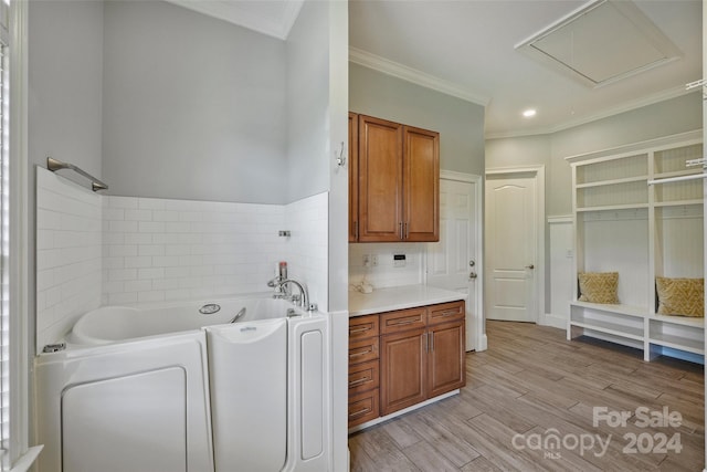 laundry area with light wood-type flooring and crown molding