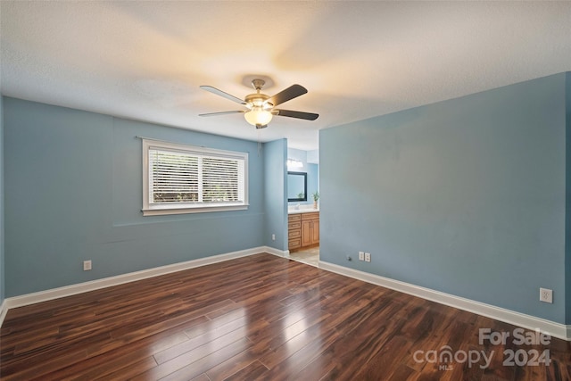 spare room with ceiling fan, a textured ceiling, and dark hardwood / wood-style flooring