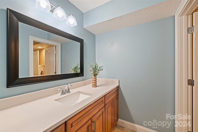 bathroom with a textured ceiling, vanity, and tile patterned floors