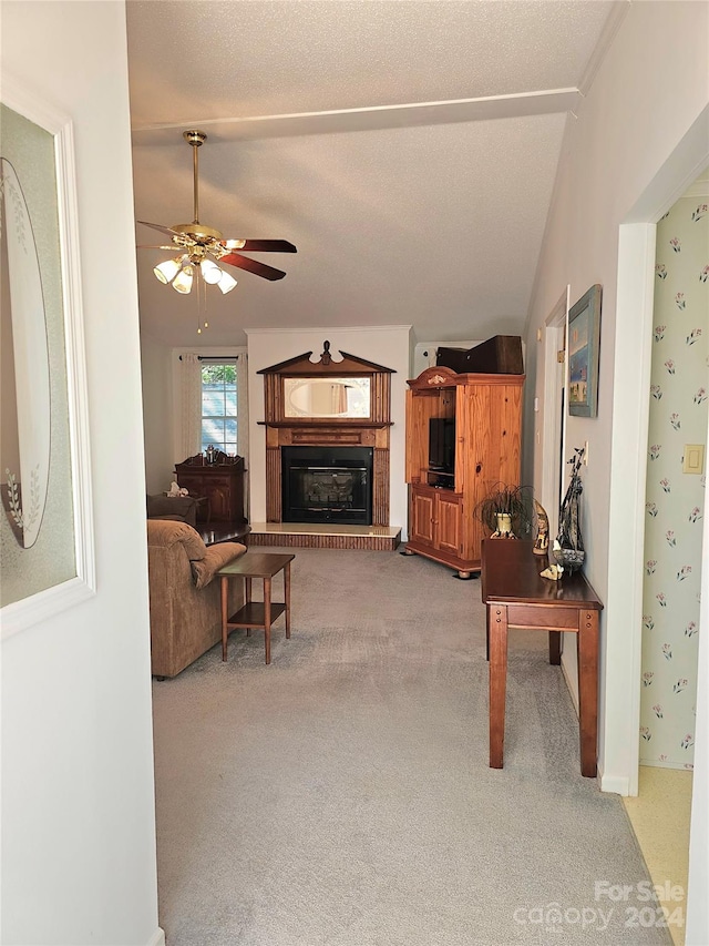 living room featuring carpet floors, a textured ceiling, lofted ceiling, and ceiling fan