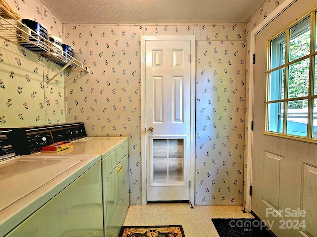 washroom featuring a textured ceiling and washing machine and dryer