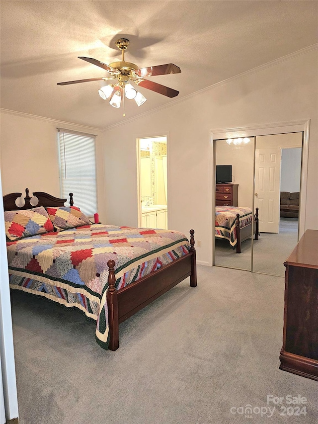 bedroom with a closet, a textured ceiling, light colored carpet, ornamental molding, and ceiling fan