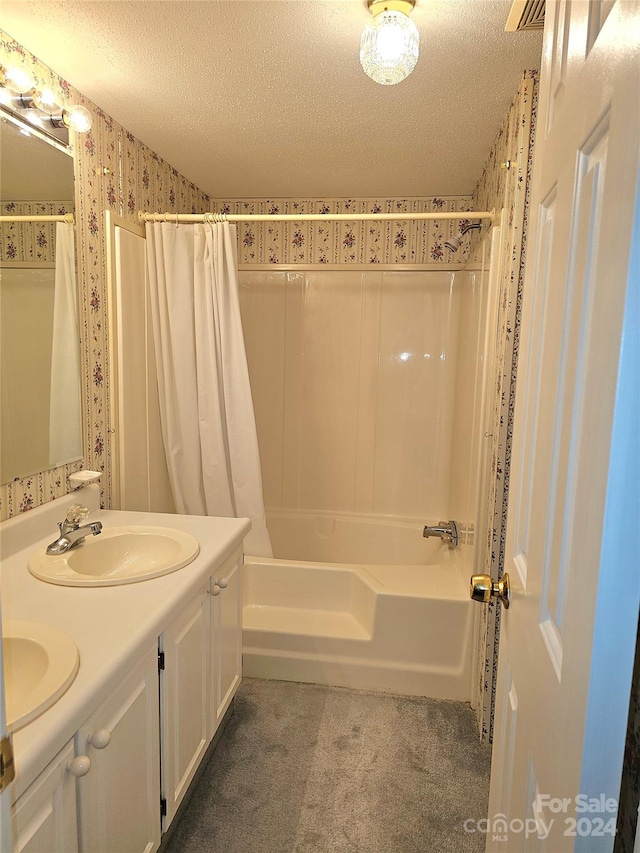 bathroom with shower / tub combo with curtain, a textured ceiling, and vanity