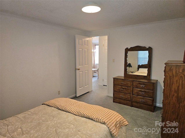 carpeted bedroom with a textured ceiling and ornamental molding