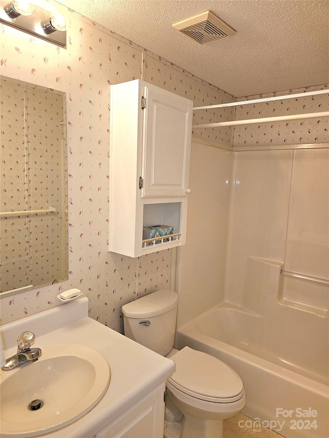 full bathroom with bathtub / shower combination, a textured ceiling, vanity, and toilet