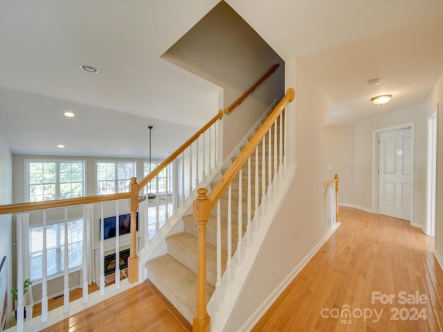 stairway featuring a notable chandelier and hardwood / wood-style flooring