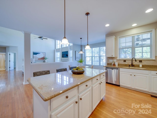 kitchen with a kitchen island, white cabinetry, dishwasher, light hardwood / wood-style floors, and sink