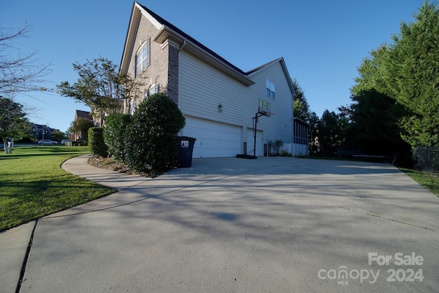 view of side of property featuring a garage and a lawn