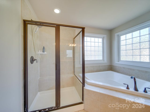 bathroom with a chandelier and separate shower and tub