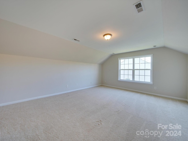 bonus room featuring light carpet and vaulted ceiling