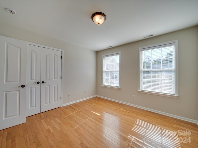 unfurnished bedroom with light hardwood / wood-style flooring and a closet