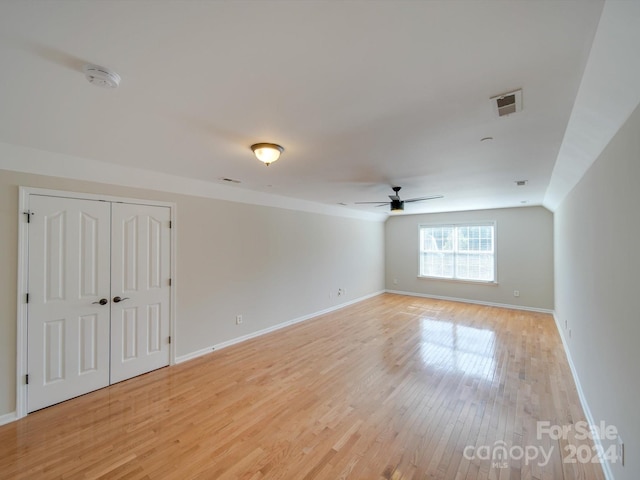 spare room featuring vaulted ceiling, light wood-type flooring, and ceiling fan