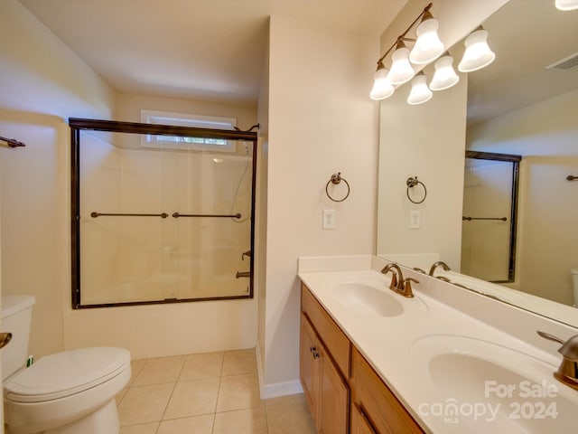 full bathroom featuring vanity, bath / shower combo with glass door, toilet, and tile patterned floors