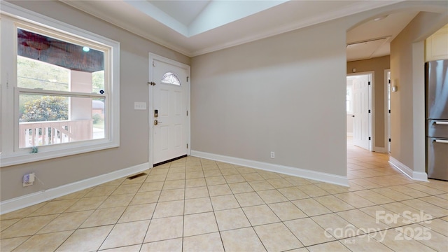 tiled entrance foyer with vaulted ceiling and crown molding