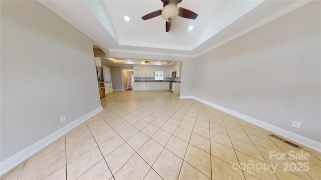 unfurnished living room featuring ceiling fan, light tile patterned flooring, a raised ceiling, and ornamental molding