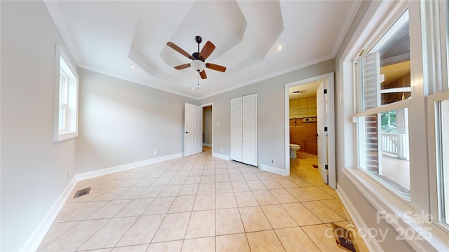 unfurnished bedroom with ensuite bathroom, ceiling fan, a raised ceiling, and crown molding