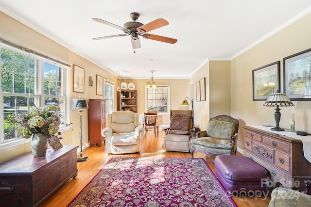 living room with ornamental molding, light wood-type flooring, and ceiling fan