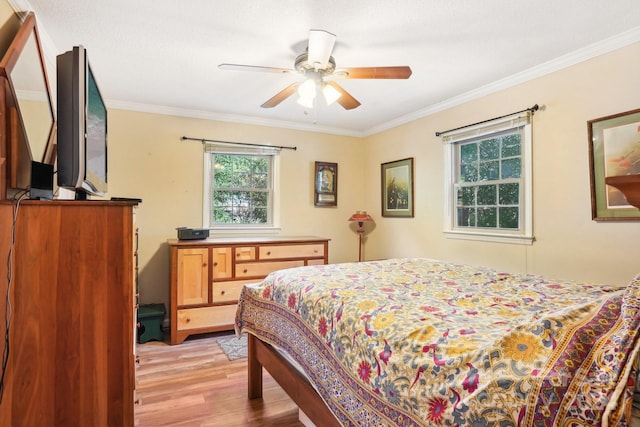 bedroom with light hardwood / wood-style flooring, crown molding, and ceiling fan