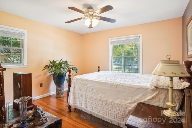 bedroom with light hardwood / wood-style floors, multiple windows, and ceiling fan