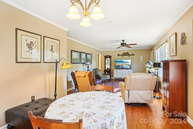 dining area featuring hardwood / wood-style floors, crown molding, and ceiling fan with notable chandelier