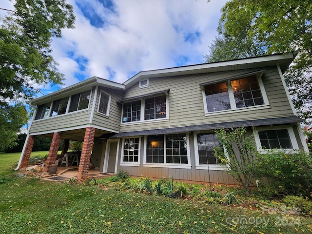 back of property with a patio and a lawn