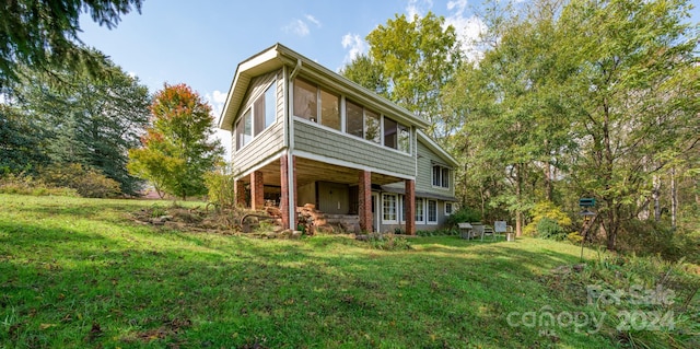 rear view of property featuring a lawn