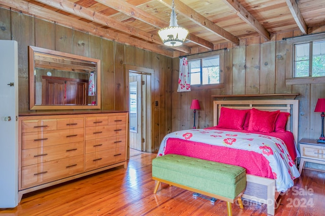 bedroom with hardwood / wood-style flooring, beamed ceiling, wood walls, and wood ceiling