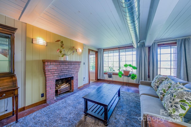 living room with a brick fireplace, a healthy amount of sunlight, wood walls, and wooden ceiling