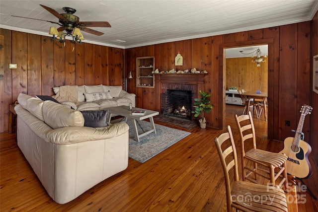 139 Neely Rd, Brevard, NC 28712 - living area with wooden walls, a ceiling fan, ornamental molding, a brick fireplace, and hardwood / wood-style flooring