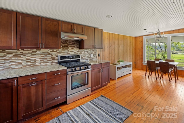 139 Neely Rd, Brevard, NC 28712 - kitchen with light wood-type flooring, under cabinet range hood, gas stove, and decorative backsplash