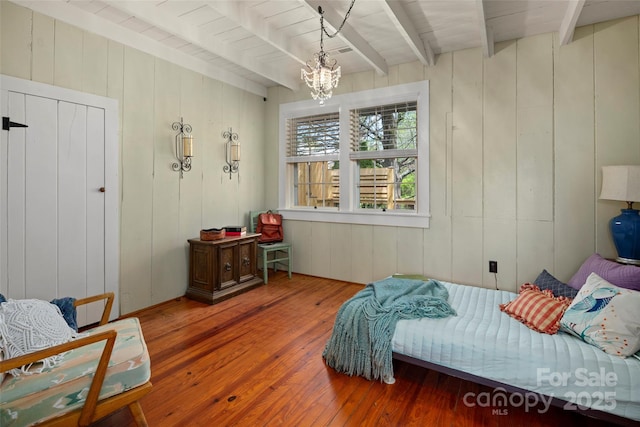 139 Neely Rd, Brevard, NC 28712 - bedroom with wood walls, a notable chandelier, beam ceiling, and hardwood / wood-style floors