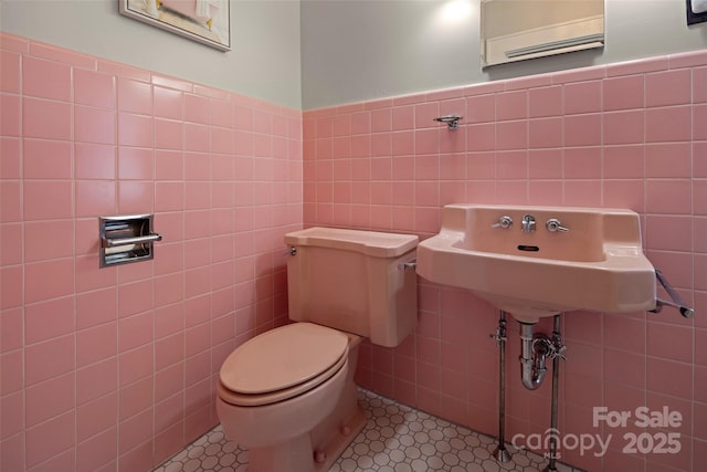 139 Neely Rd, Brevard, NC 28712 - bathroom with tile walls, toilet, a wainscoted wall, and a sink