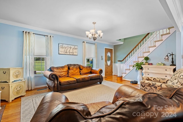 living room featuring ornamental molding, a chandelier, and light hardwood / wood-style flooring