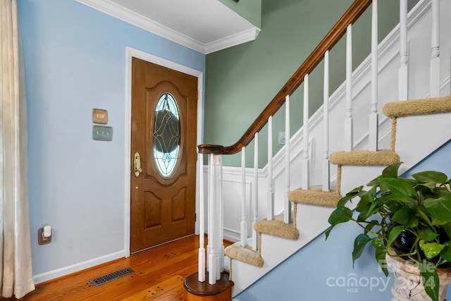 foyer with hardwood / wood-style flooring and crown molding