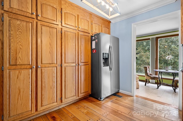 kitchen featuring ornamental molding, stainless steel fridge with ice dispenser, and light hardwood / wood-style floors