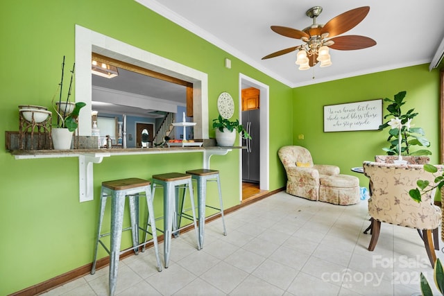 interior space with ornamental molding, ceiling fan, and light tile patterned floors