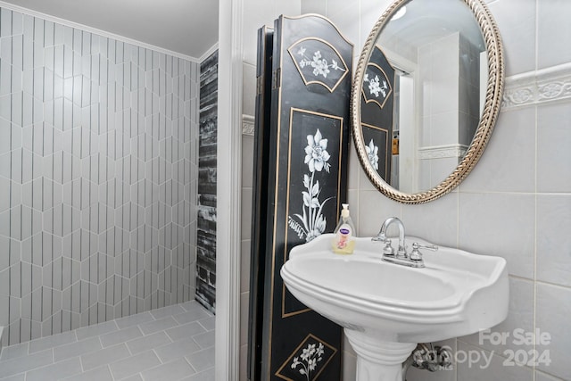 bathroom with crown molding and tile walls