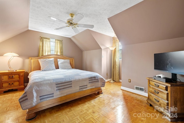 bedroom with lofted ceiling, light parquet floors, a textured ceiling, and ceiling fan