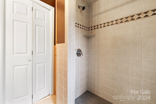 bathroom with tile patterned flooring, tiled shower, and tile walls