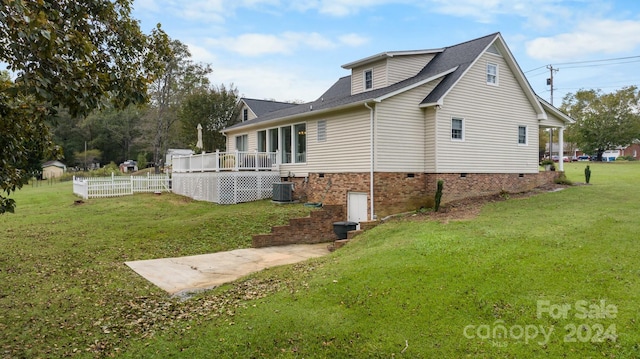 view of property exterior with a wooden deck, central AC unit, and a lawn