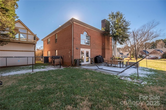 rear view of house with french doors, a yard, and a patio area