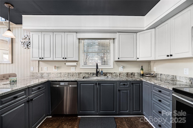 kitchen with appliances with stainless steel finishes, hanging light fixtures, light stone countertops, white cabinets, and sink